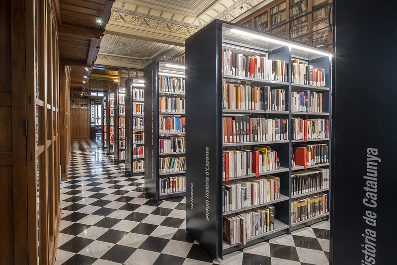 Detall de prestatgeries metàl·liques amb llibres dins la biblioteca de l'Ateneu Barcelonès